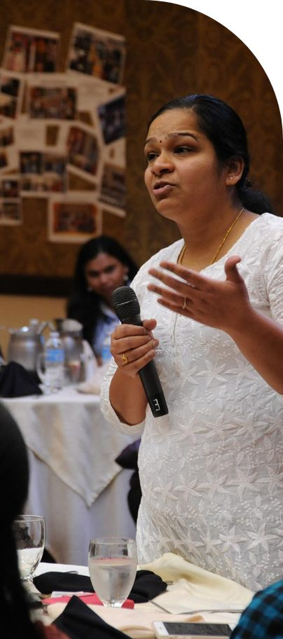 A community member speaking into a microphone at a stakeholder engagement event.